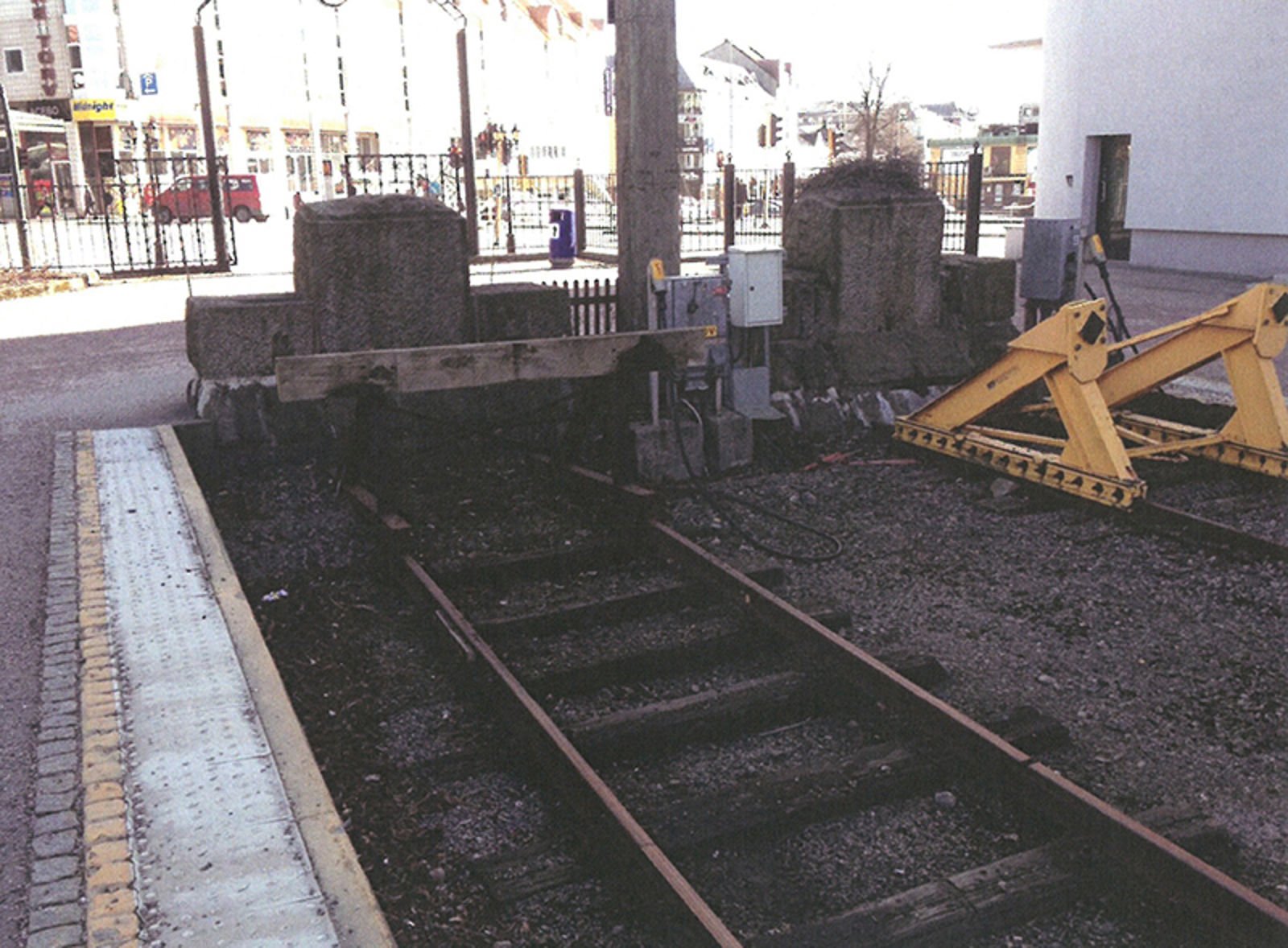 Sporstopper med treplanke montert foran en betongbarriere.