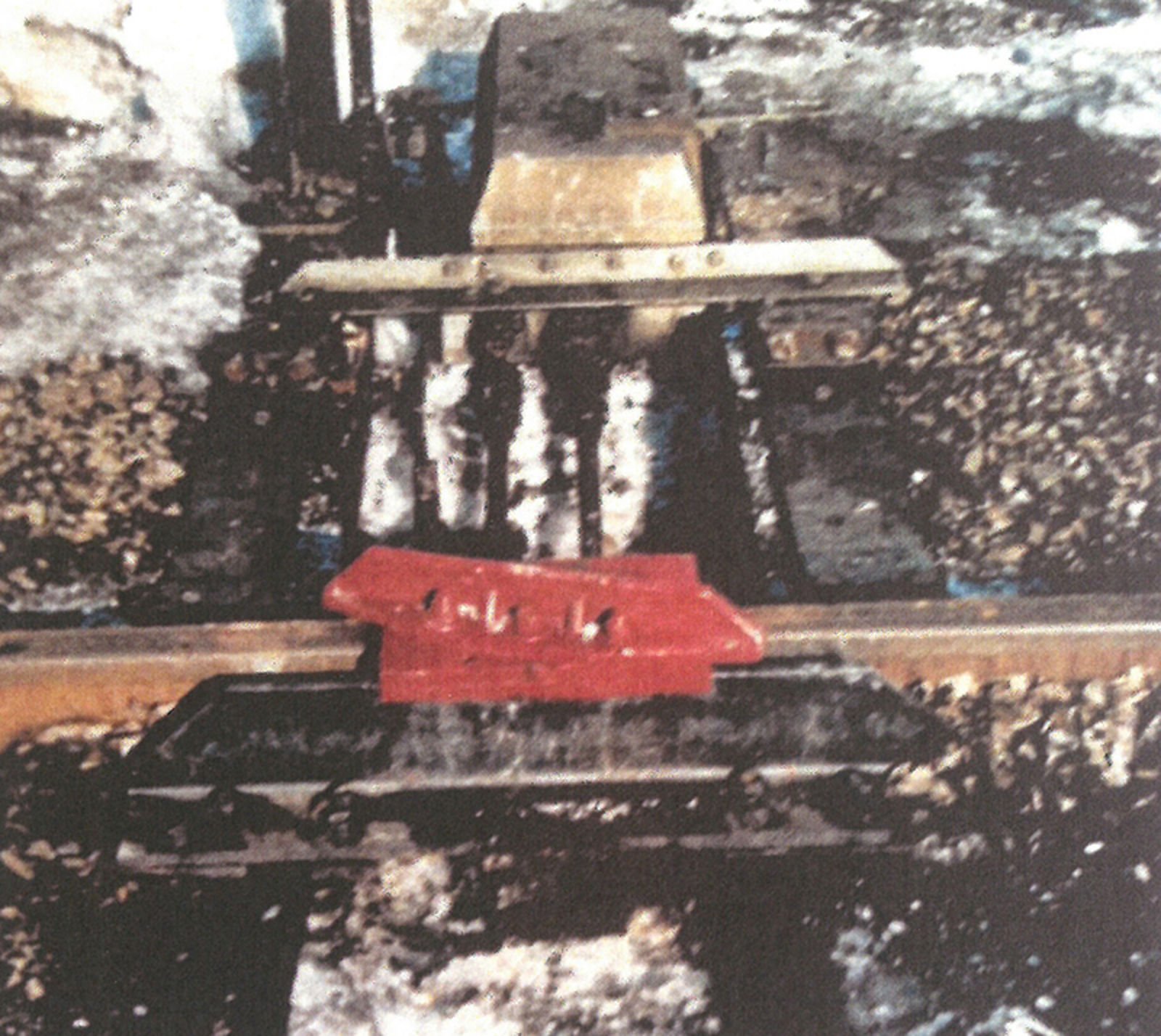 Rød sporsperre montert på jernbaneskinne for å hindre rullende materiell.