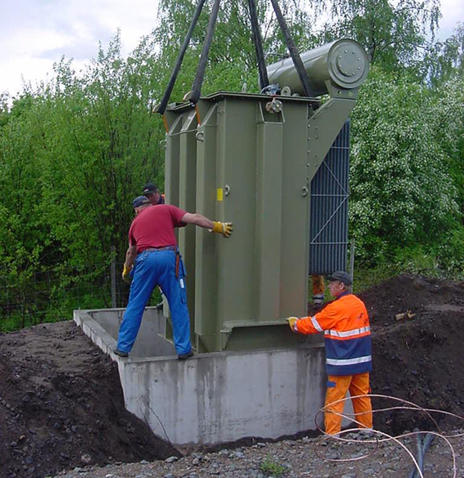 Montering av autotransformator på fundament med kran og manuell plassering i felt.