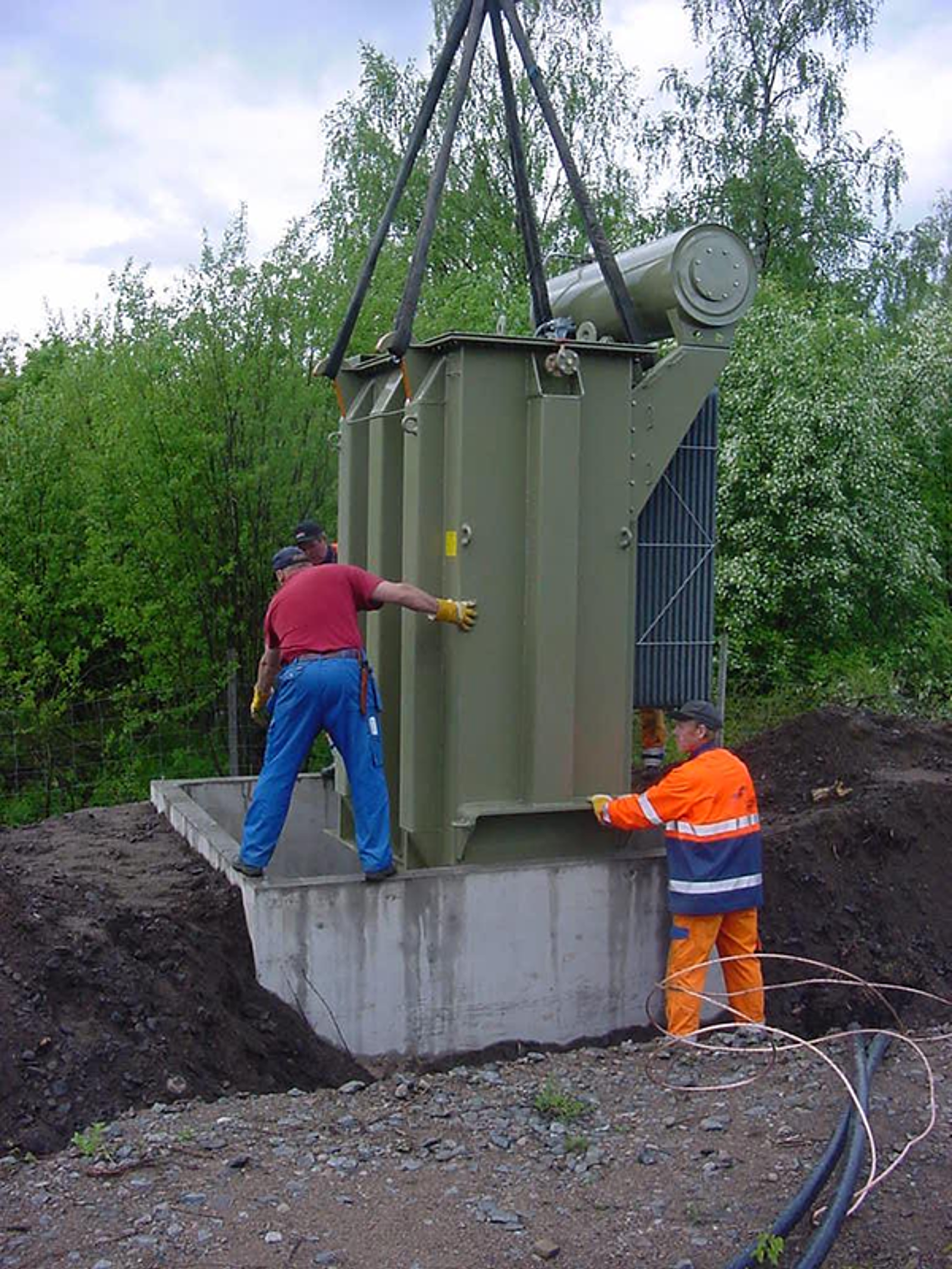 Montering av autotransformator på fundament med kran og manuell plassering i felt.