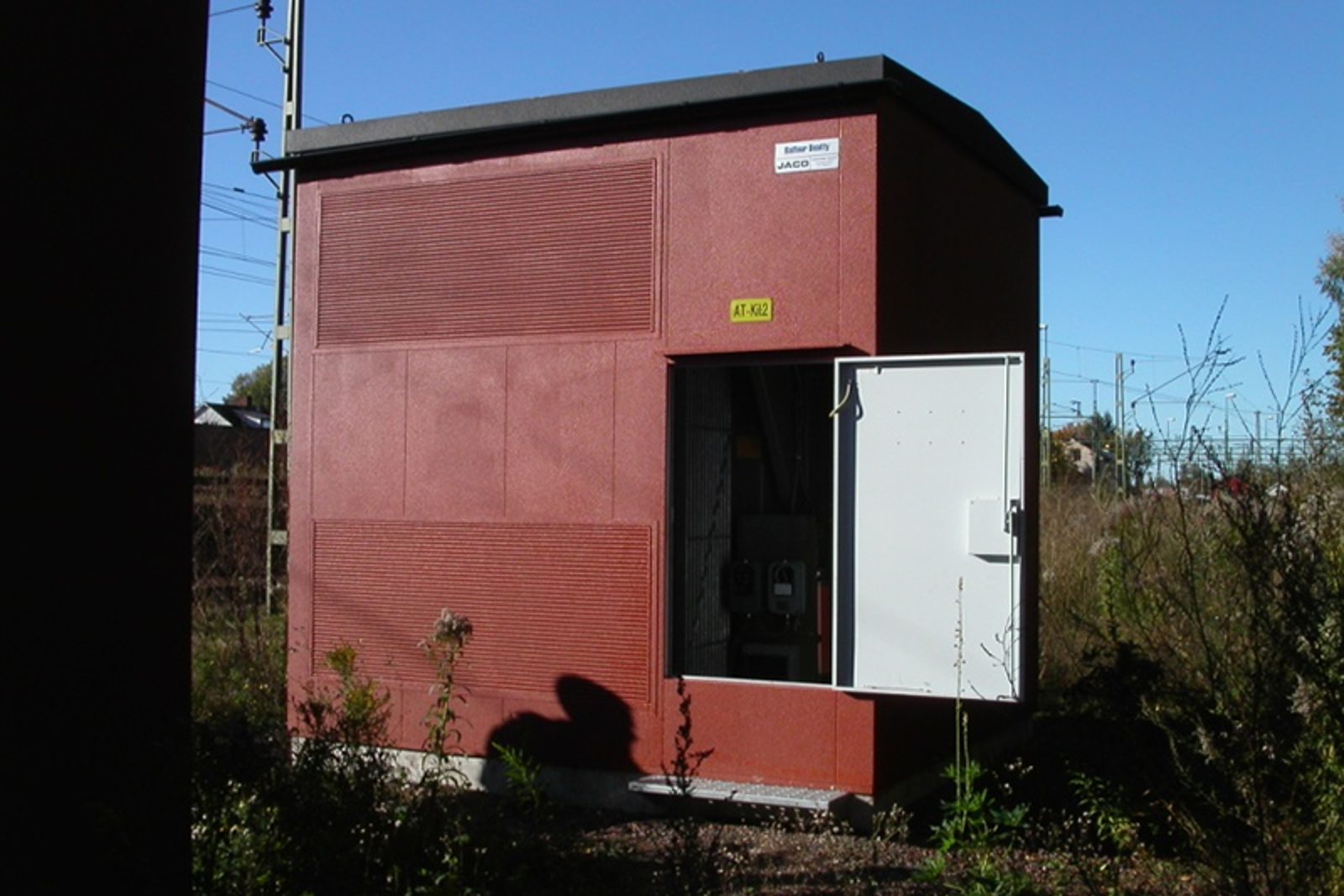 Kiosk for autotransformator med åpen dør i spormiljø.