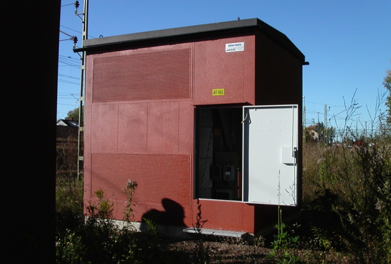 Kiosk for autotransformator med åpen dør i spormiljø.