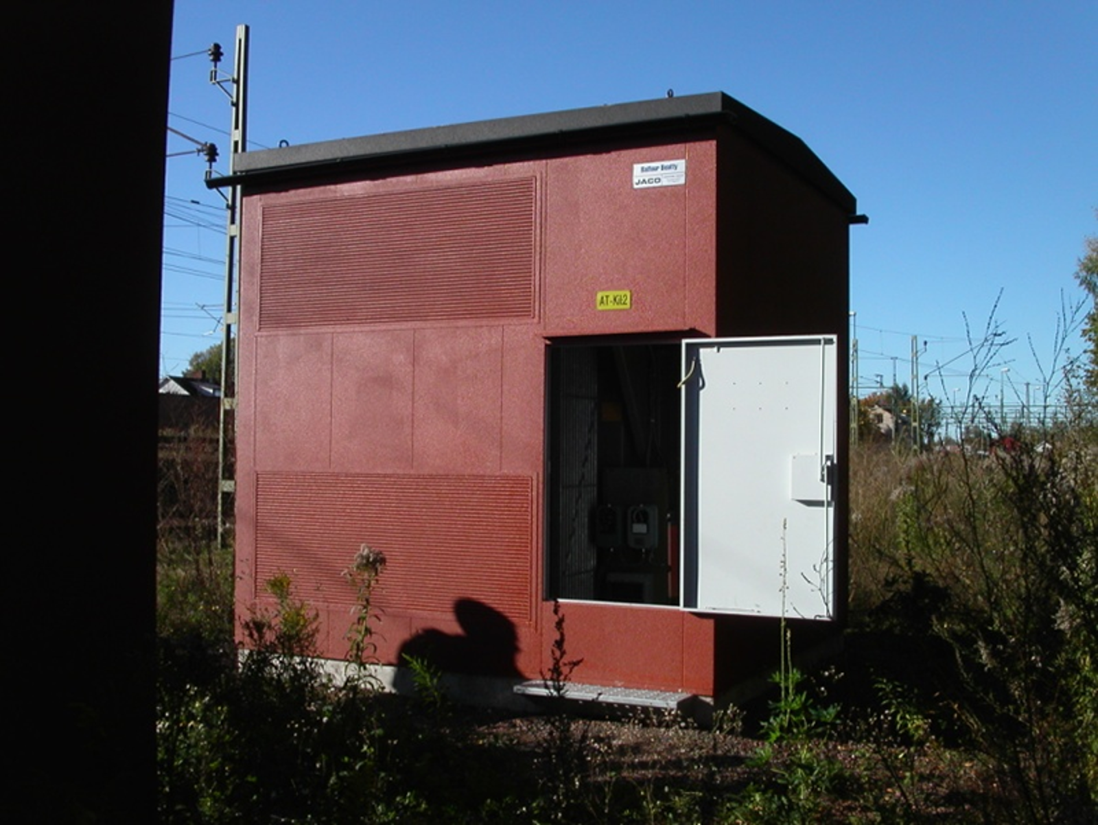 Kiosk for autotransformator med åpen dør i spormiljø.