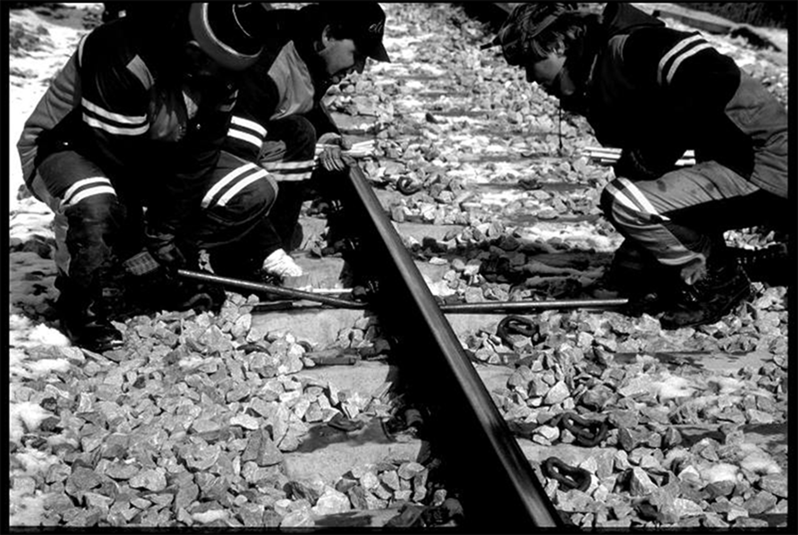 Arbeidere frigjør skinnefoten for spenningsfrigjøring.