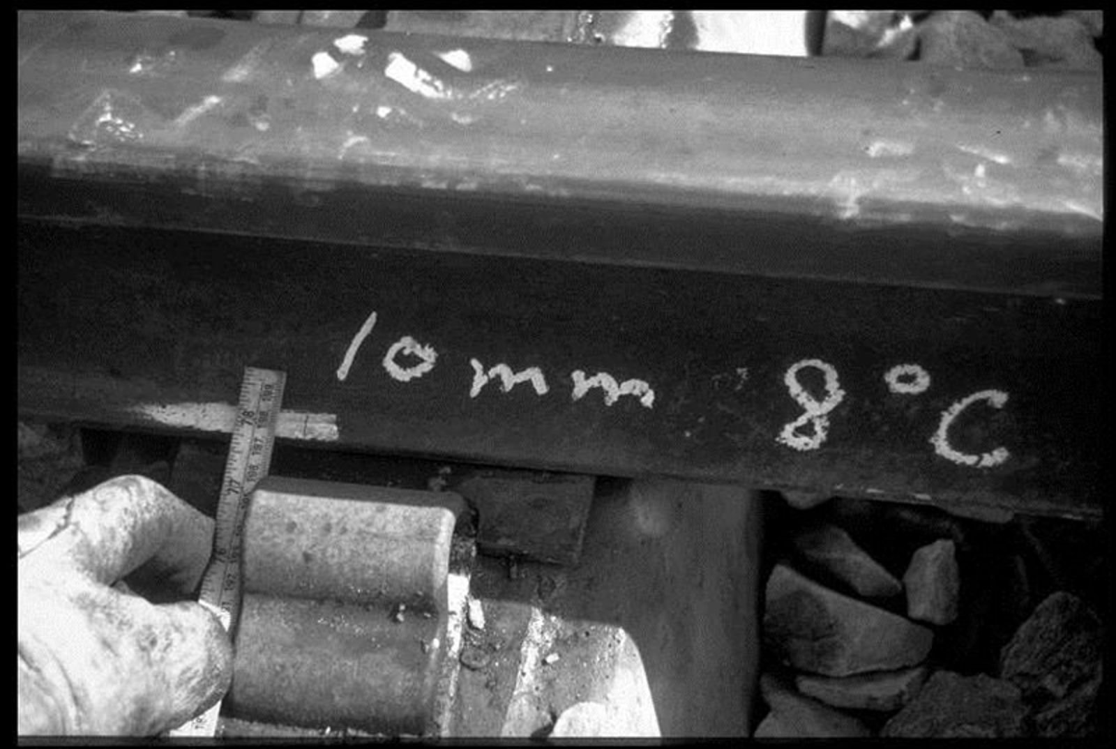 Måling av dilatasjonsmerke på skinnefoten med oppgitt verdi.