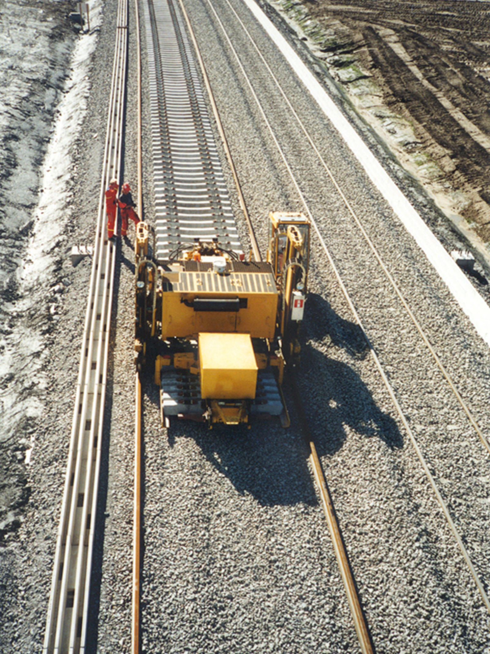 Svillelegging på Gardermobanen med maskinell plassering av sviller på gruslagt underlag.