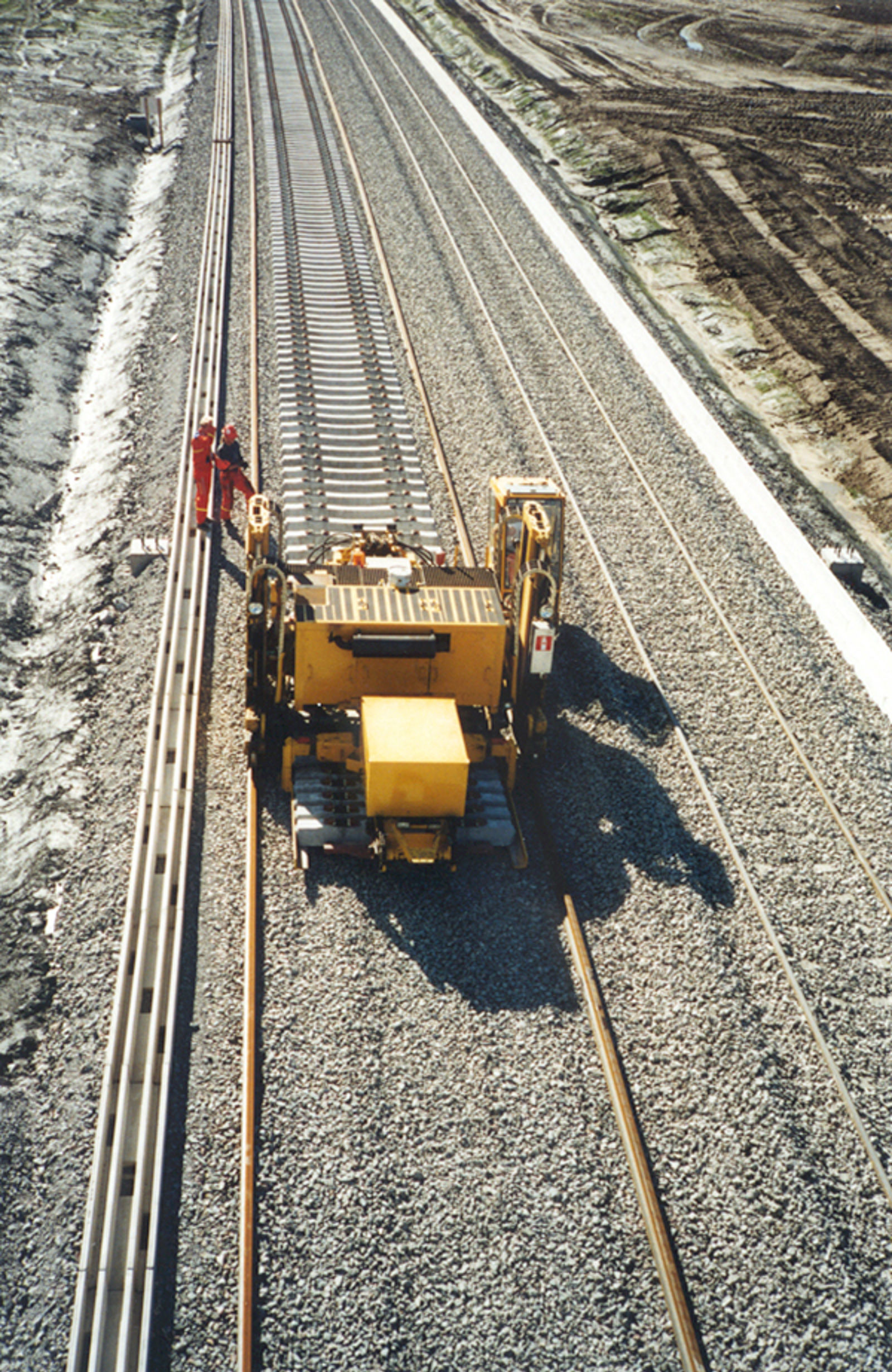 Svillelegging på Gardermobanen med maskinell plassering av sviller på gruslagt underlag.