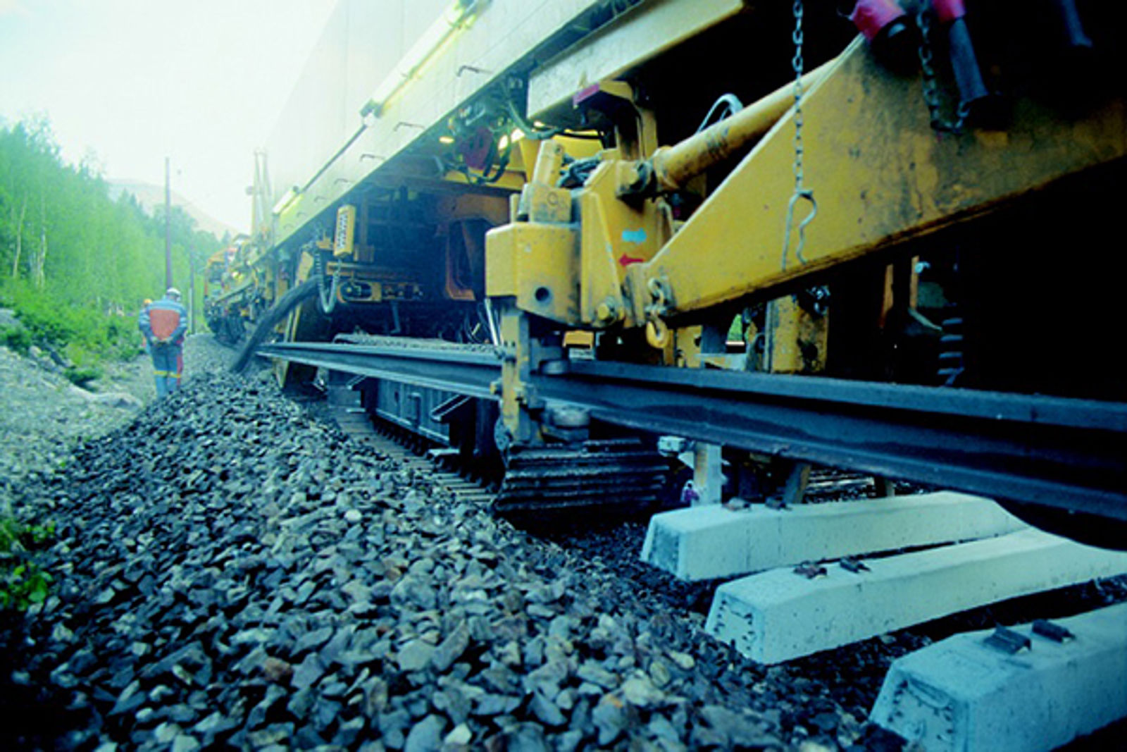 Sporombyggingstoget SPOT fjerner gamle sviller og legger nye under skinner på pukkballast.
