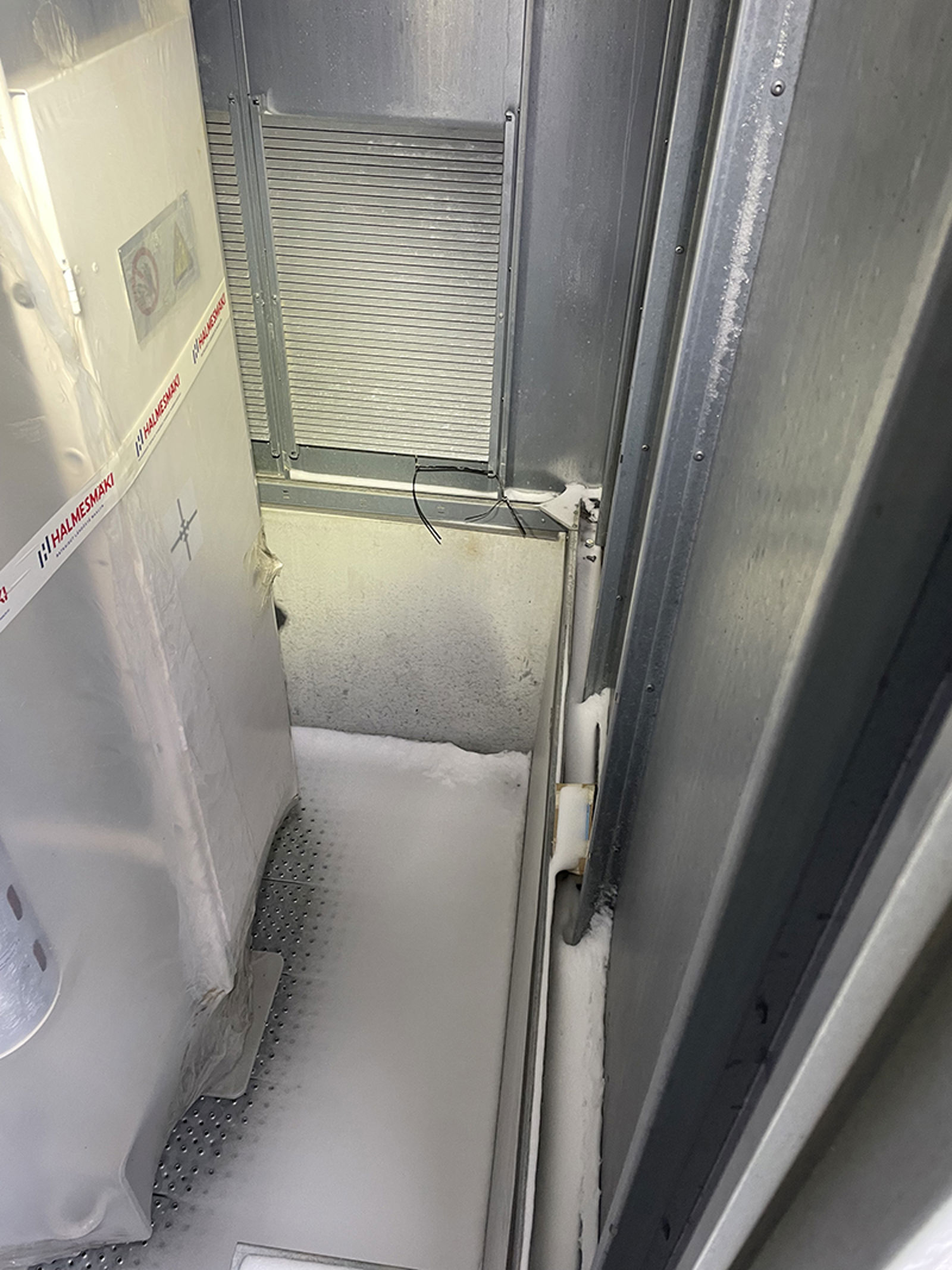 Snø i bunn av kiosk med synlige ventilasjonsrister som slipper inn snøfokk om vinteren.