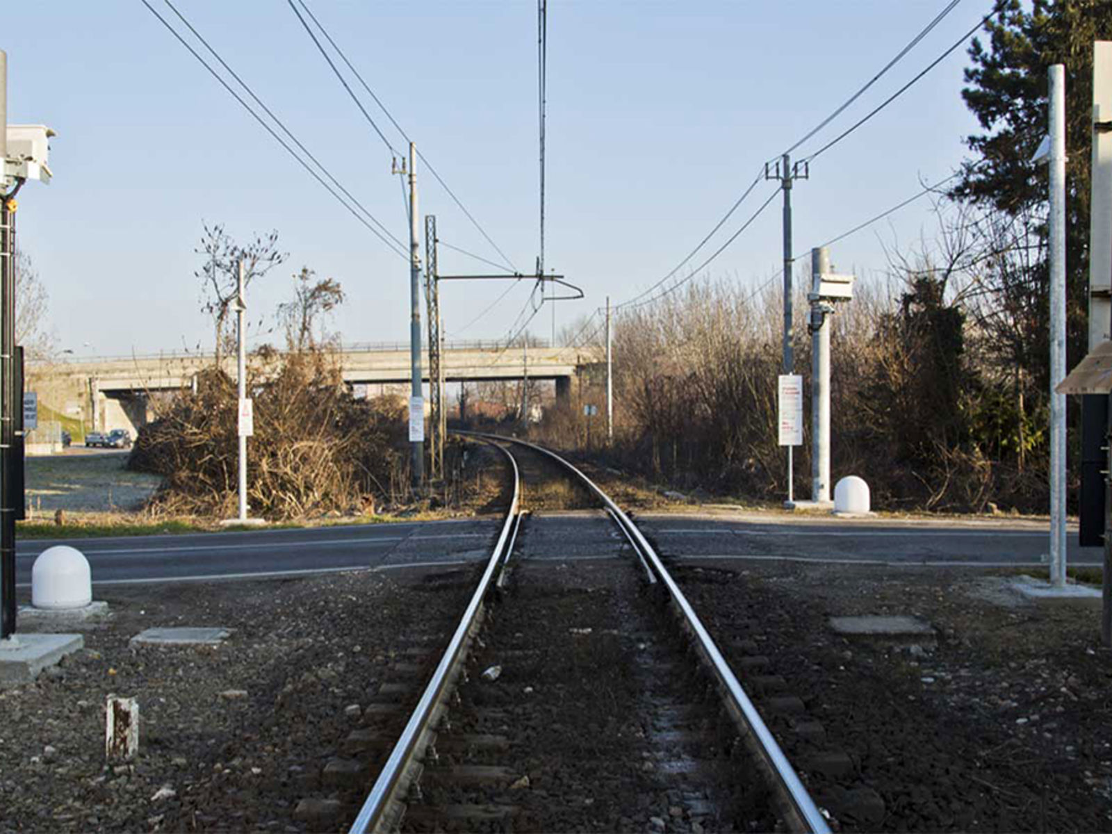 Planovergang med monterte radarer for objektdeteksjon ved jernbanespor.