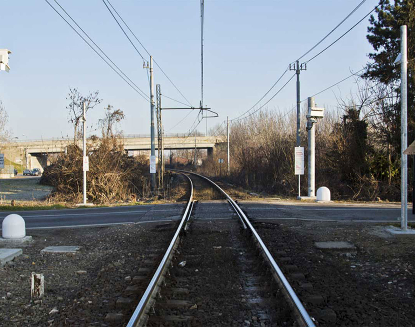 Planovergang med monterte radarer for objektdeteksjon ved jernbanespor.