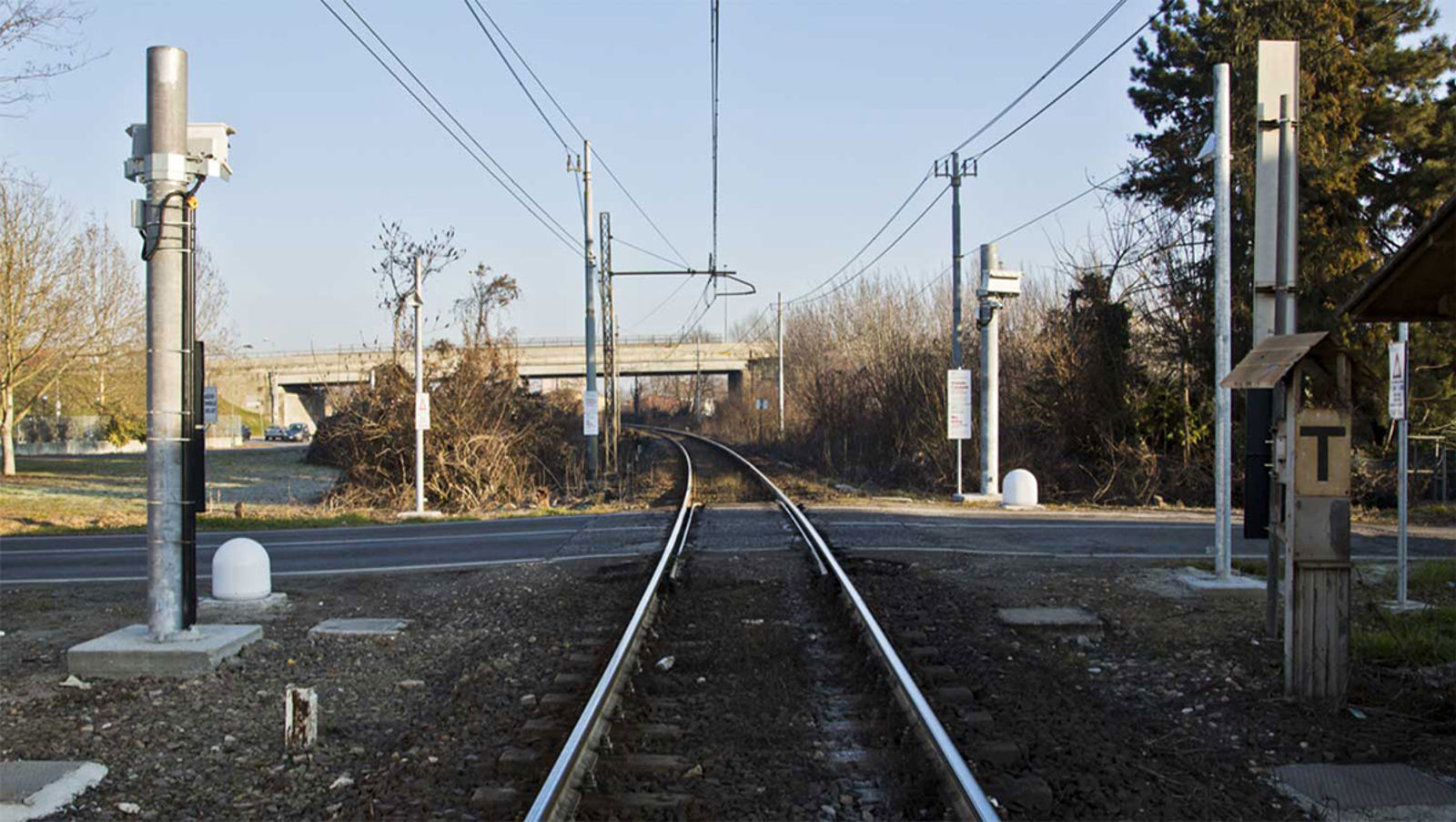 Planovergang med monterte radarer for objektdeteksjon ved jernbanespor.