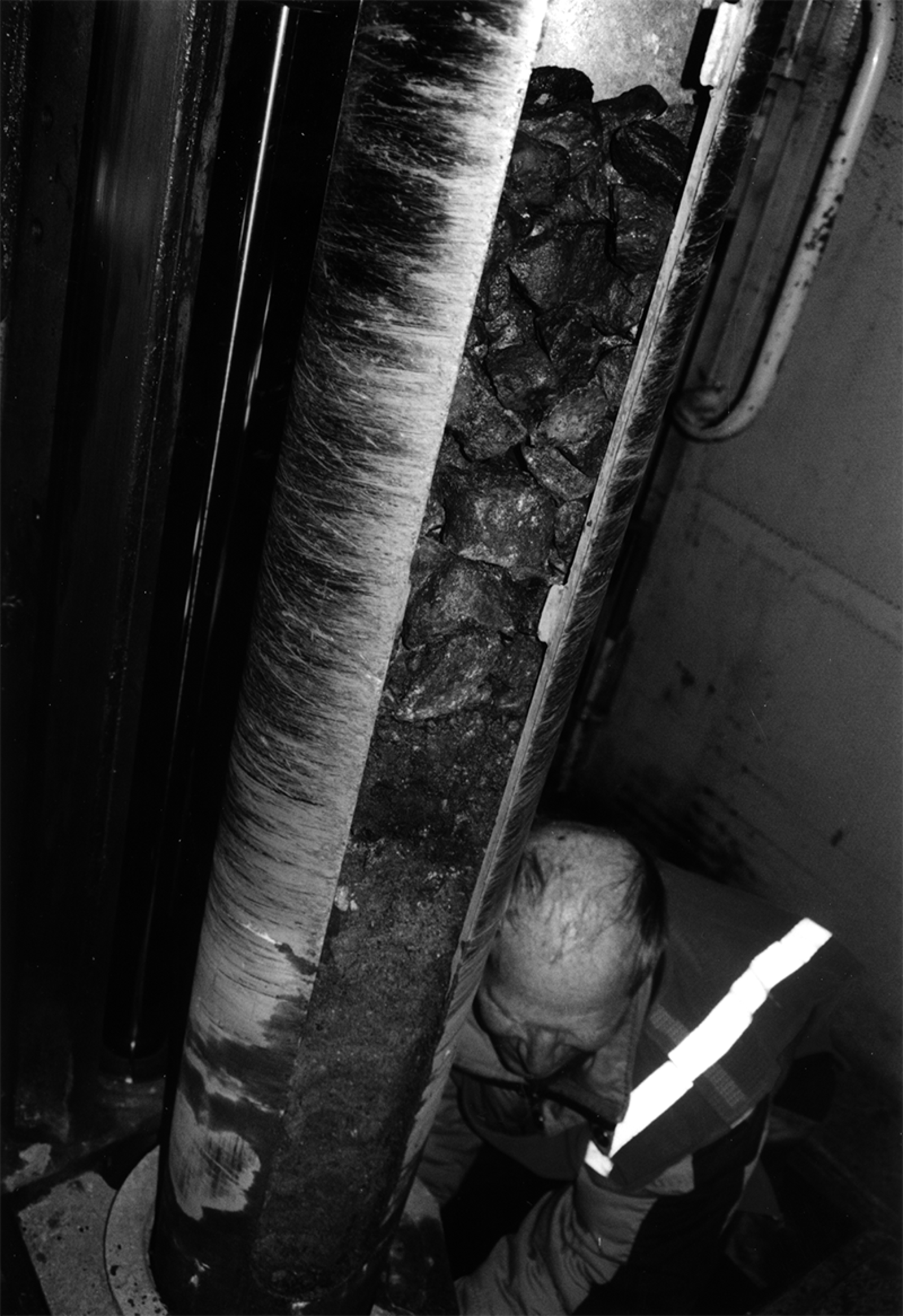 Borerør med åpen luke viser lagdeling i ballastprøven, med en person som inspiserer prøvematerialet.