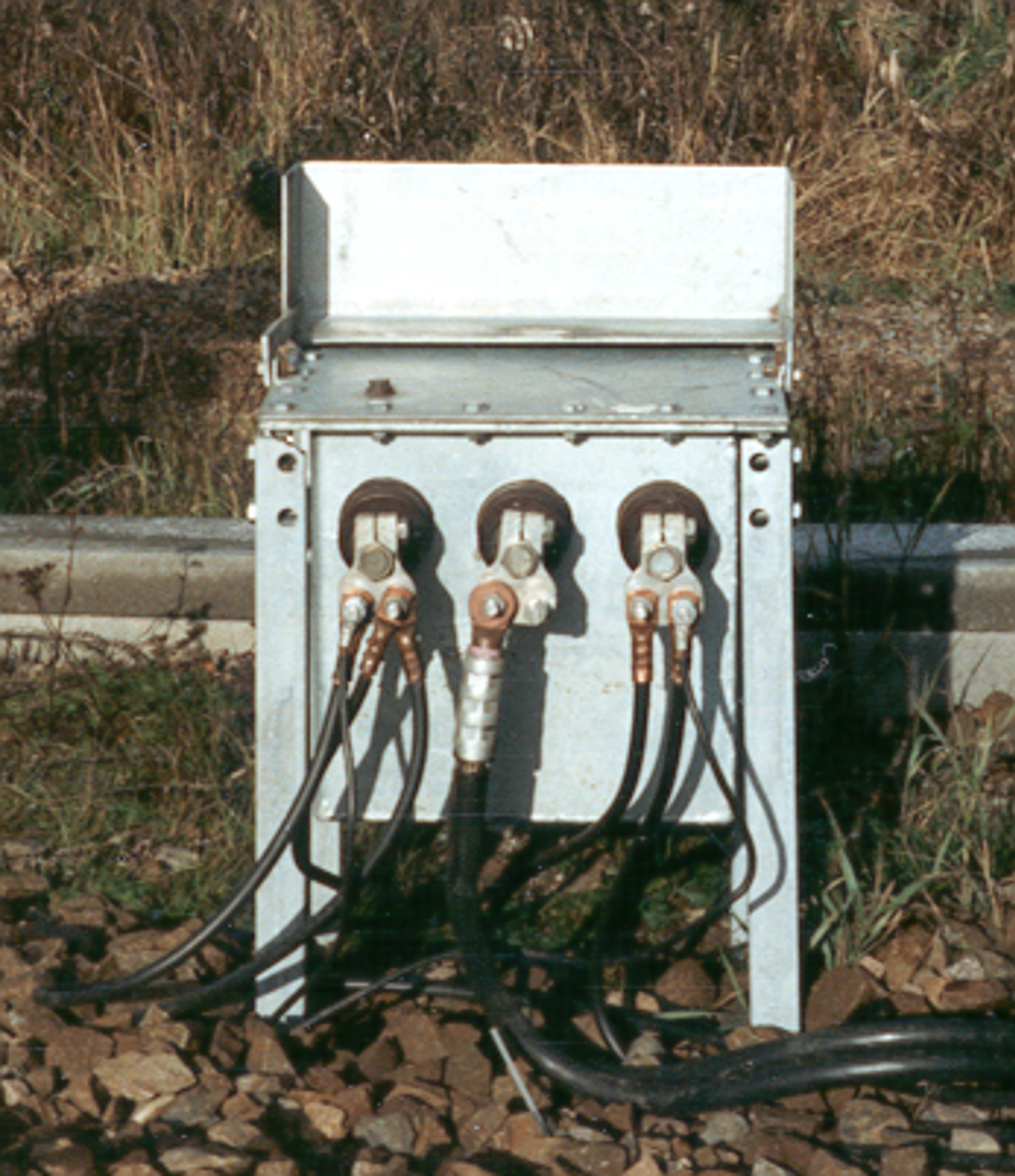 Foto av filterimpedans med tre tilkoblinger montert i kapsling ved siden av sporet.