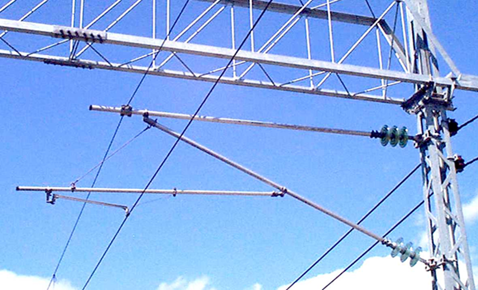 Glassisolatorer montert på utliggerarm fra mast i kontaktledningsanlegget.