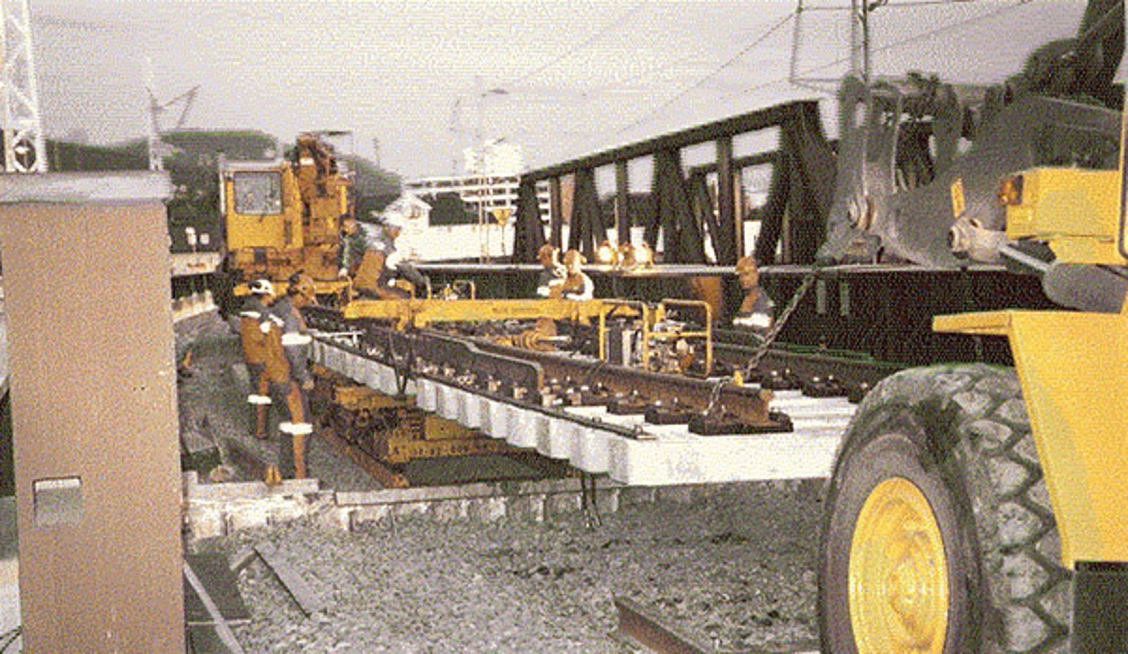 Skinnegående utstyr løfter ny sporveksel på plass under innlegging.