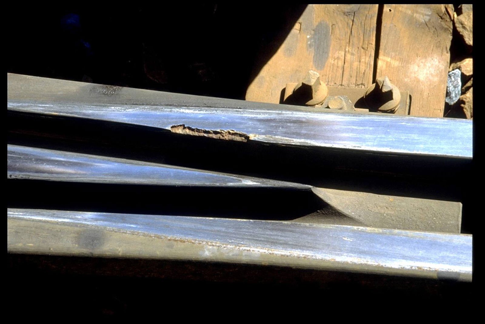 Avskalling på vingeskinne i sporveksel som følge av utmatting.