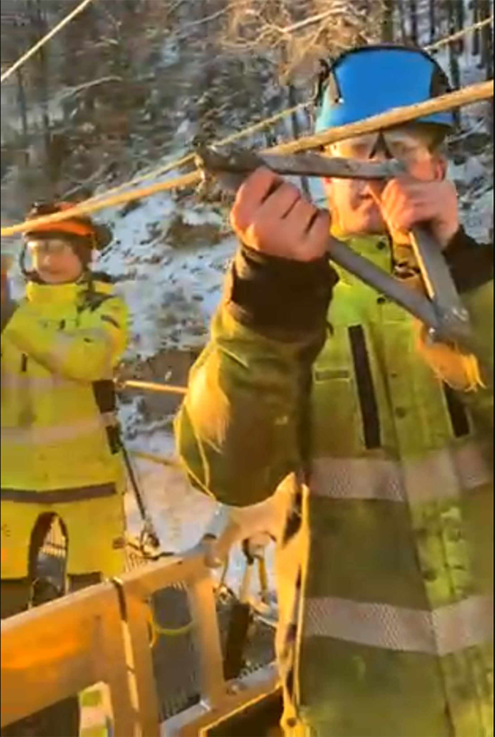 Mannskap skraper is fra kontaktledning manuelt med improvisert verktøy fra arbeidsvogn.