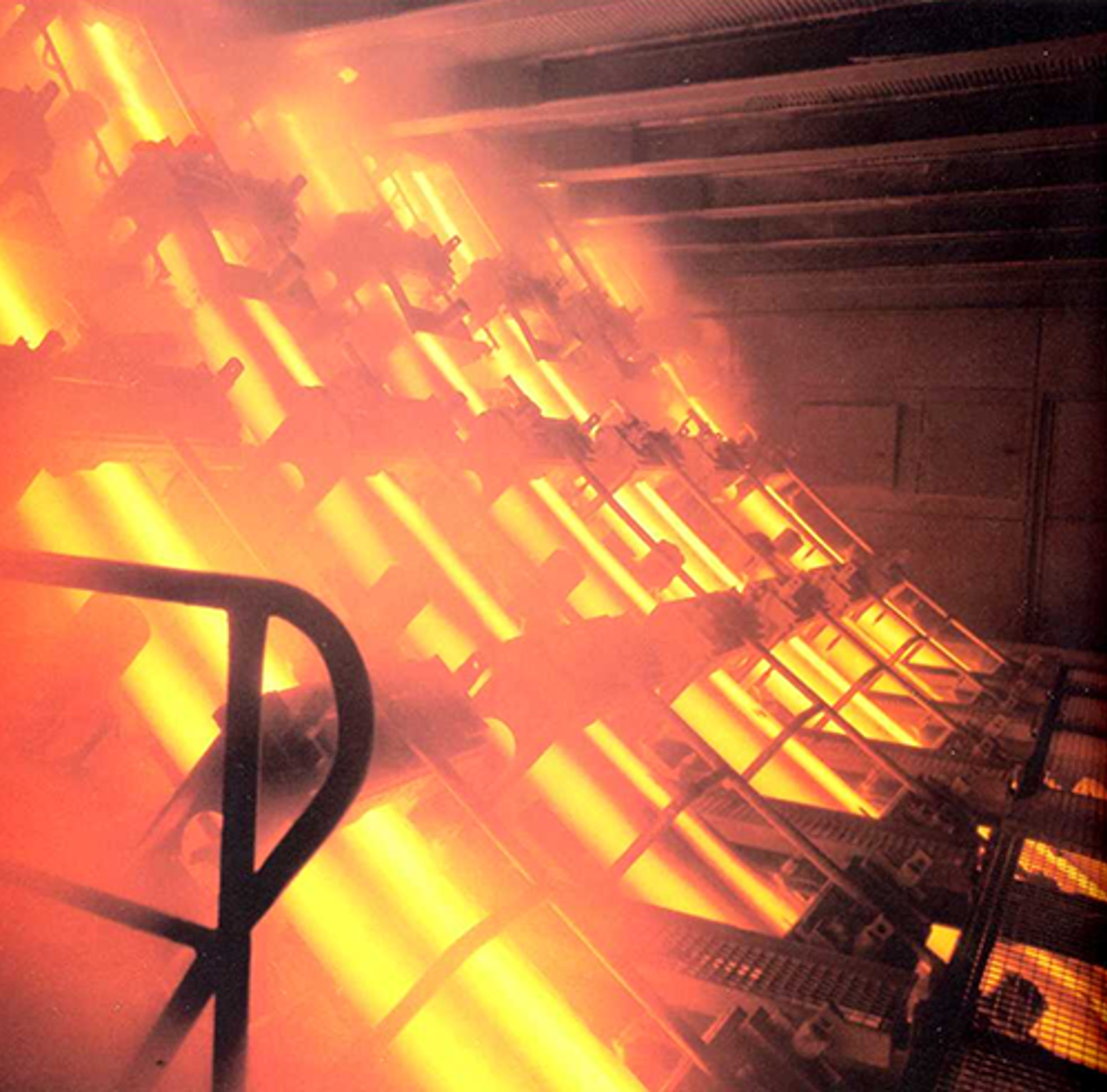 Fotografi av produksjonslinje for kontinuerlig strengstøping med glødende stålelementer.