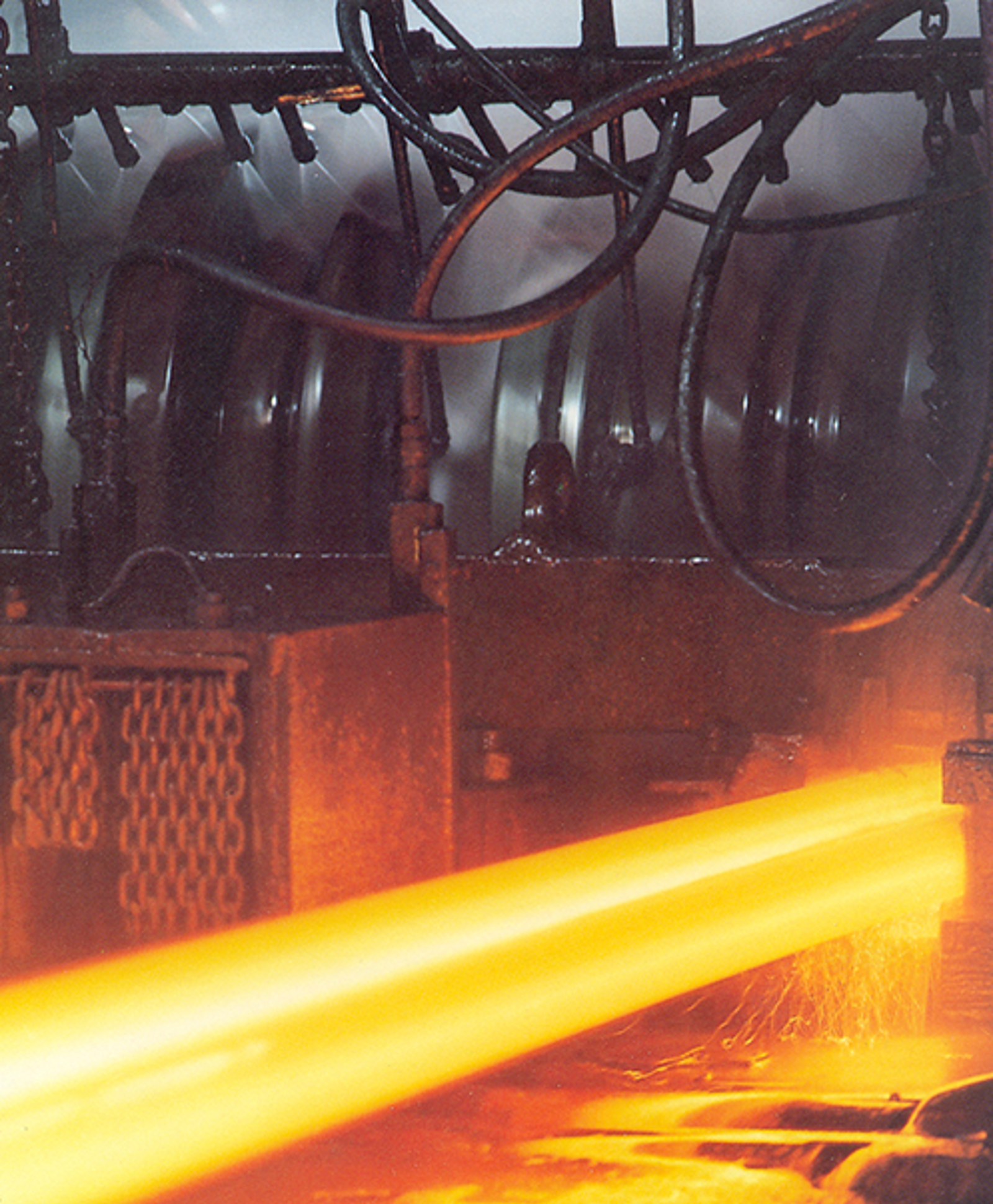 Fotografi av valsing der glødende skinner gjennomgår deformasjon.