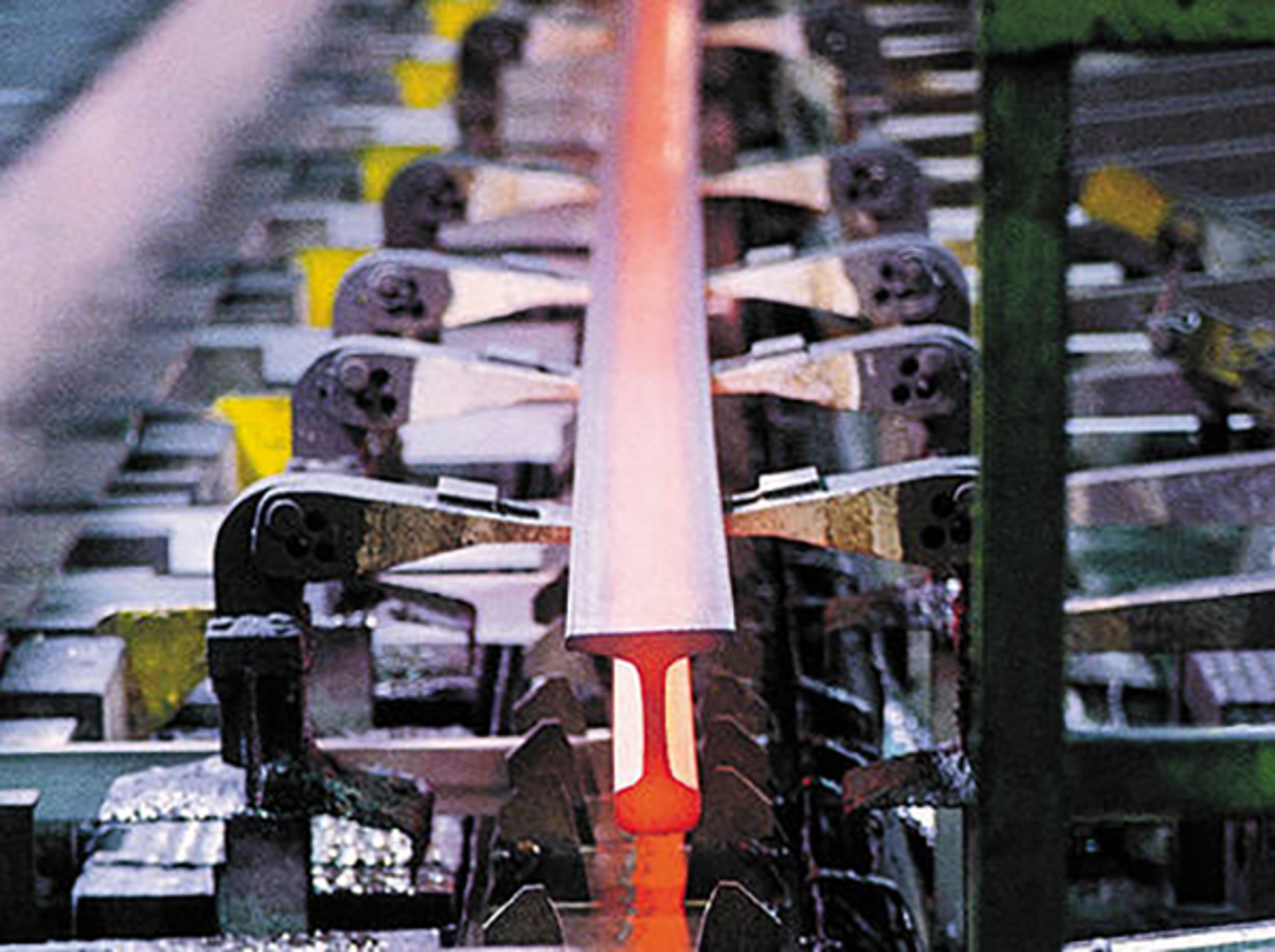 Fotografi av in-line hodeherding der en rødglødende skinne kjøles ned etter valsing.