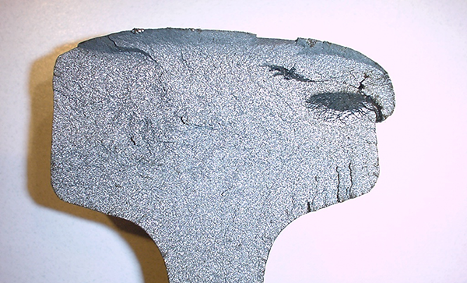 Tverrsnitt av skinnehode med avskalling på siden.