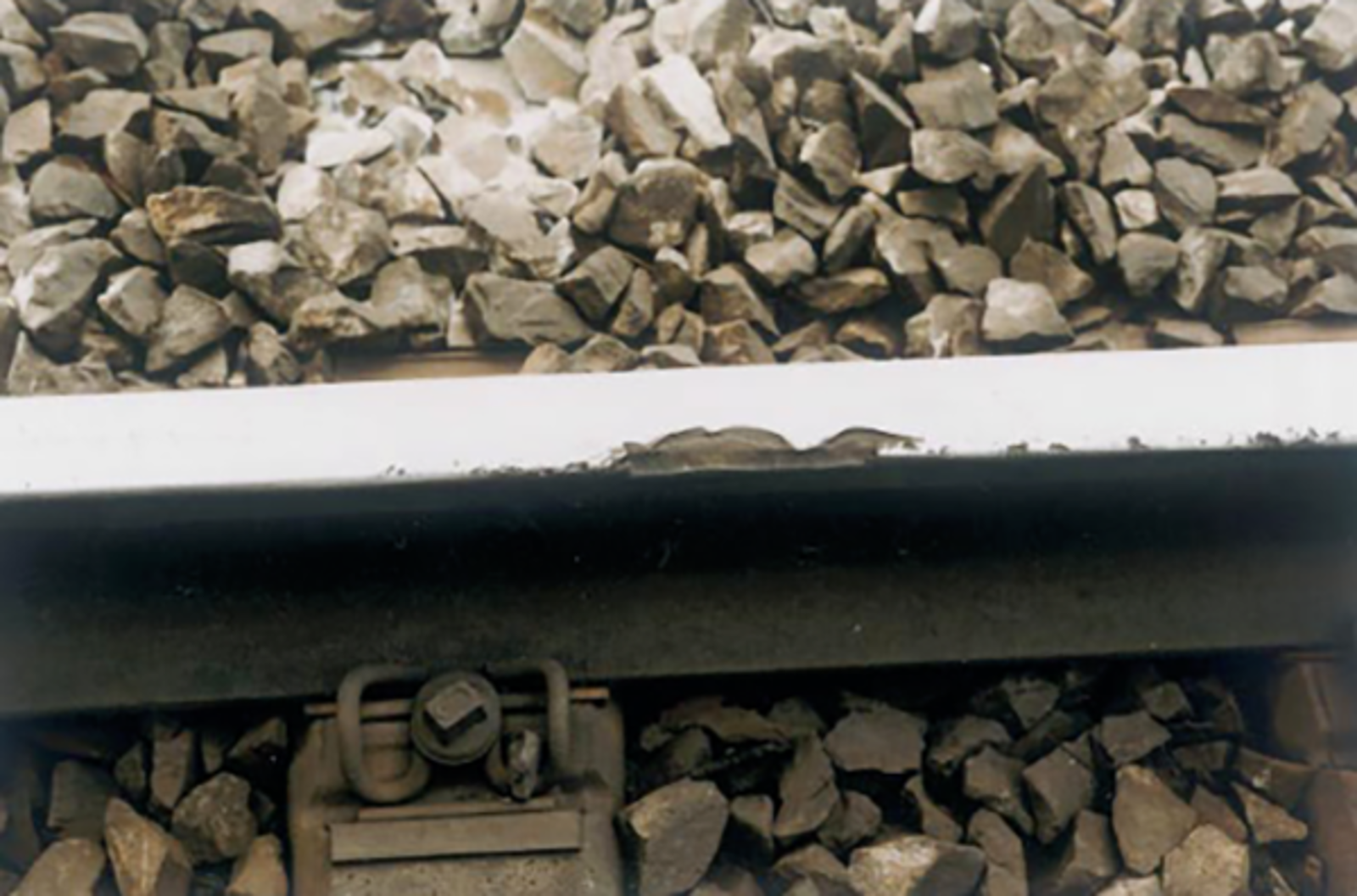 Skinne med sprekker og avskalling på kjørekanten.