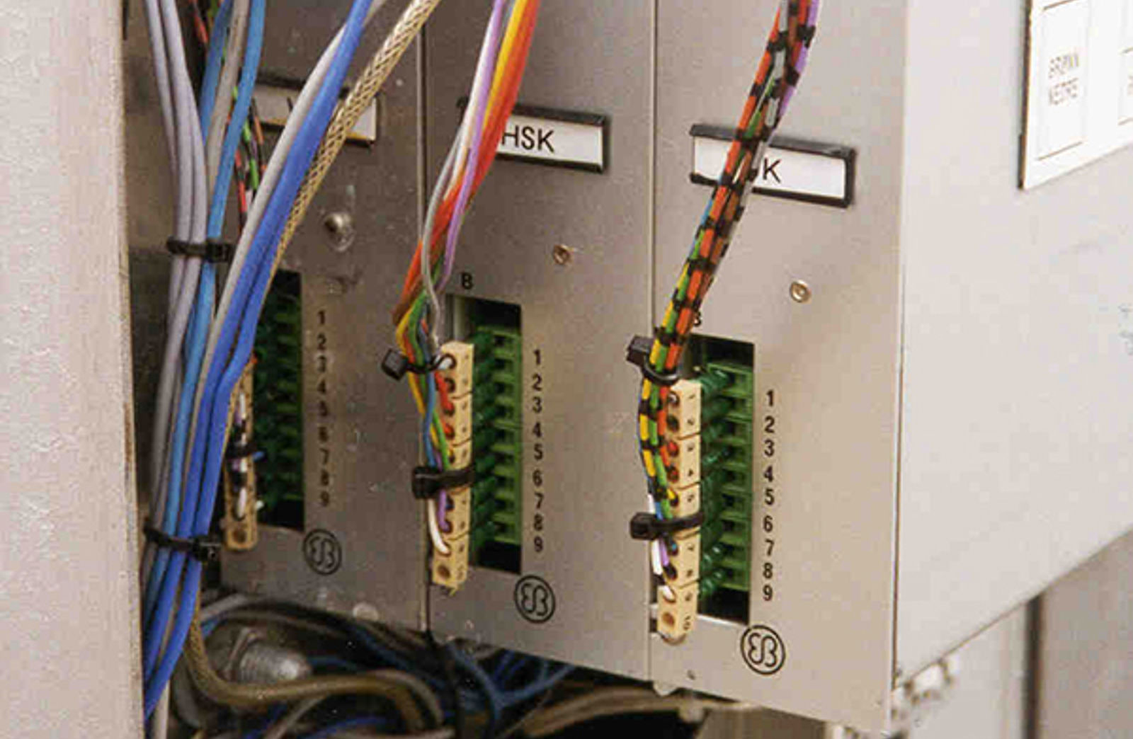Tre kodere med tilkoblinger montert i transformatorskap for signaloverføring til baliser.
