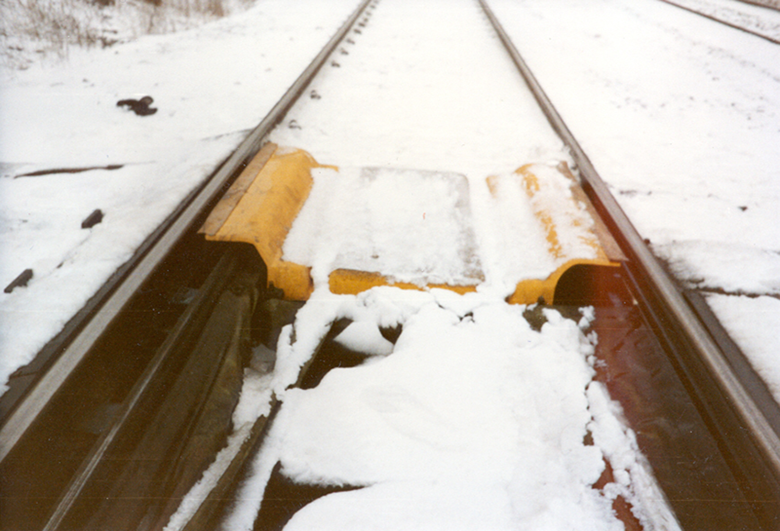 Rådegravsdeksel som beskytter svillemellomrommet og driv- og kontrollstenger mot snø.