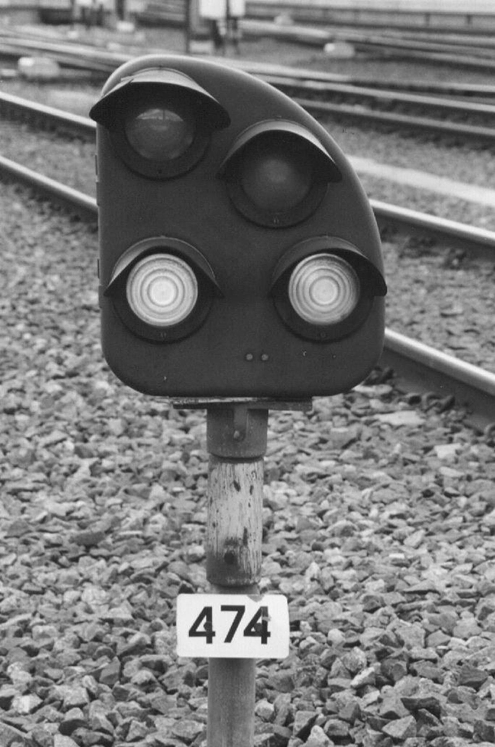 Dvergsignal med fire linseåpninger plassert lavt ved sporet.