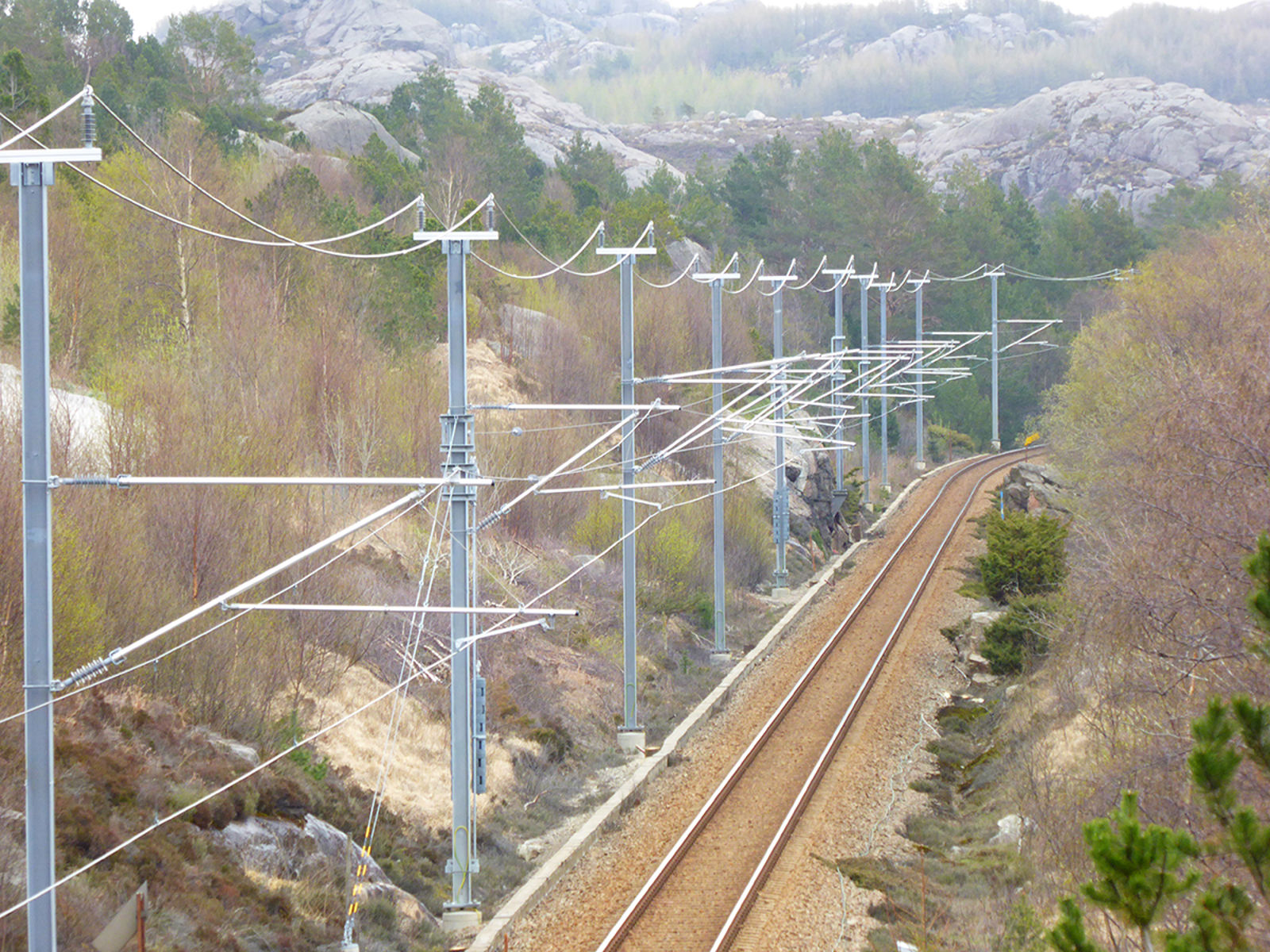 Kraftledninger og kontaktledning langs jernbanestrekning for strømforsyning til tog.